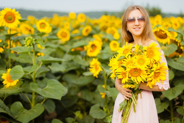 Girl in a dress among the sunflowers, the girl stands in a field of sunflowers