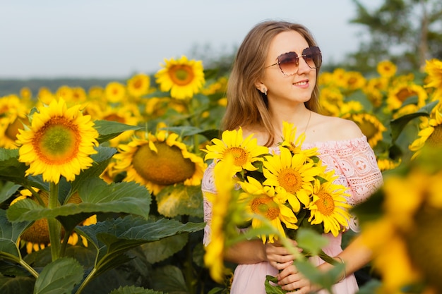 Girl in a dress among the sunflowers, the girl stands in a field of sunflowers