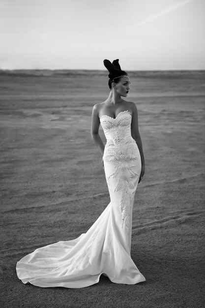 화창한 사막에서 드레스를 입은 소녀 모래 언덕에서 흰 드레스를 입은 여자 우아함과 패션 모델 웨딩 패션 및 뷰티 살롱 신부와 결혼식