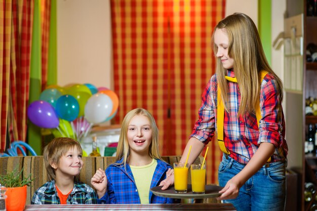 Girl dressed as waitress and visitors at cafe