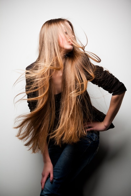 Foto ragazza vestita in giacca nera con lunghi capelli fluenti