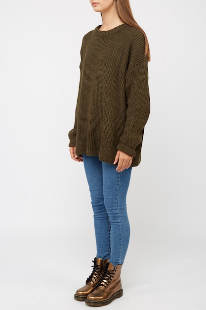 Girl dressed in a khaki sweater and jeans.