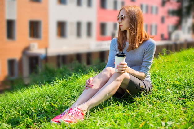 Девушка пьет кофе на открытом воздухе