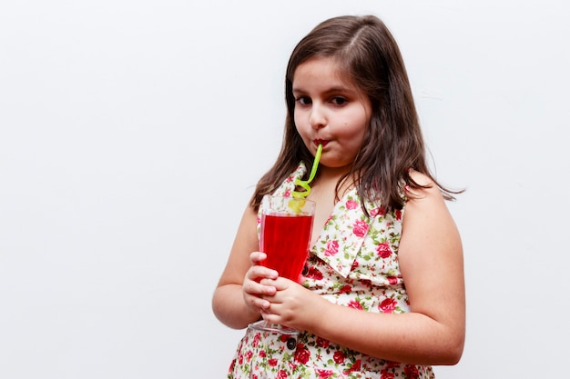 Girl drinking gooseberry refreshment with fun straw, white background