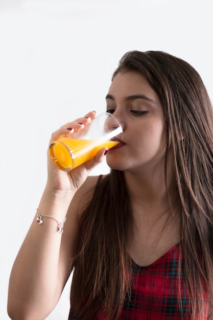 Girl drinking juice with white background.