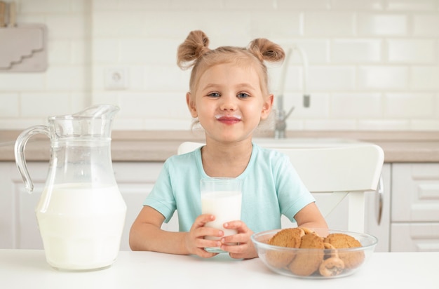 写真 クッキーと牛乳を飲む女の子