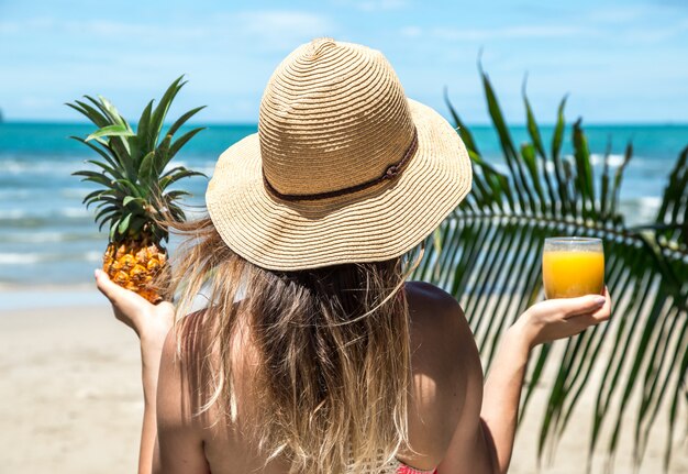 girl drinks juice on the beach