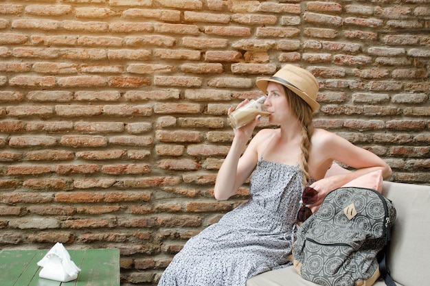 Girl drinks a latte sitting in an outdoor cafe