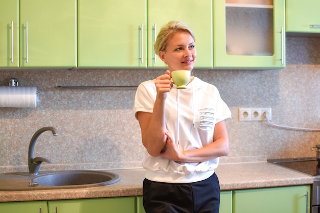 girl drinks tea in the morning in a cozy kitchen at home.