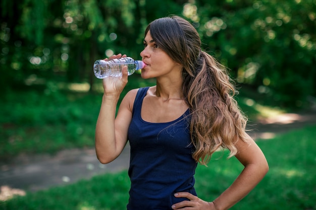 女の子はスポーツの後水を飲む