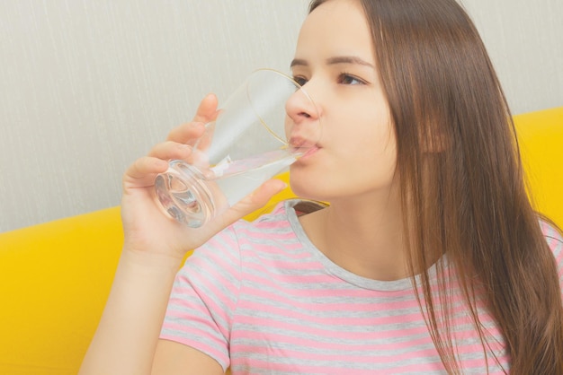 Girl drinks water from a glass