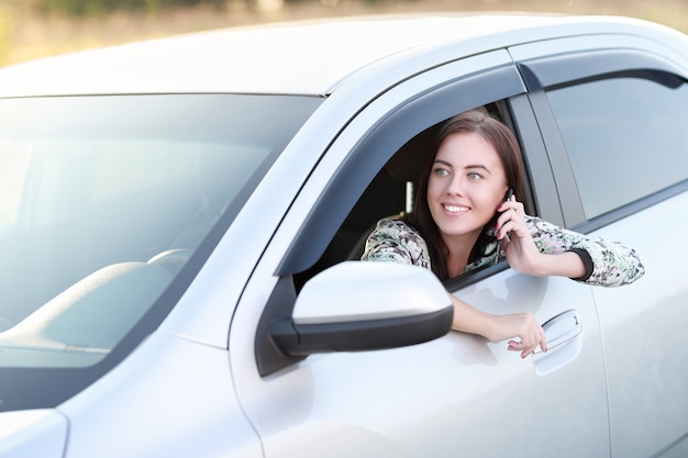 車に座っている電話を持つ女の子の運転手