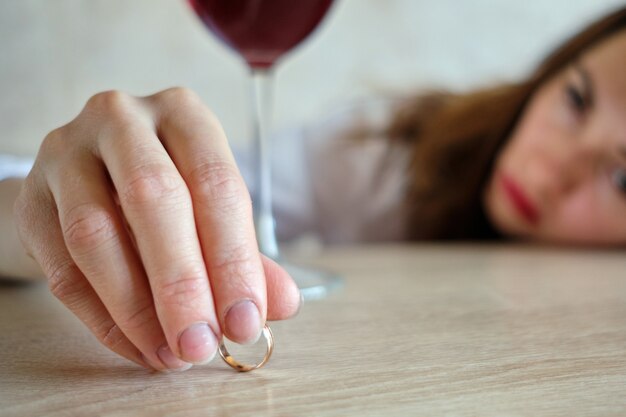 The girl drunk from wine lies her head on the table after losing her job.