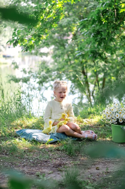 A girl and a duckling in the summer outdoors Gute babies Happiness