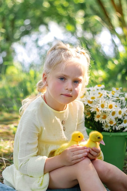 A girl and a duckling in the summer outdoors Gute babies Happiness