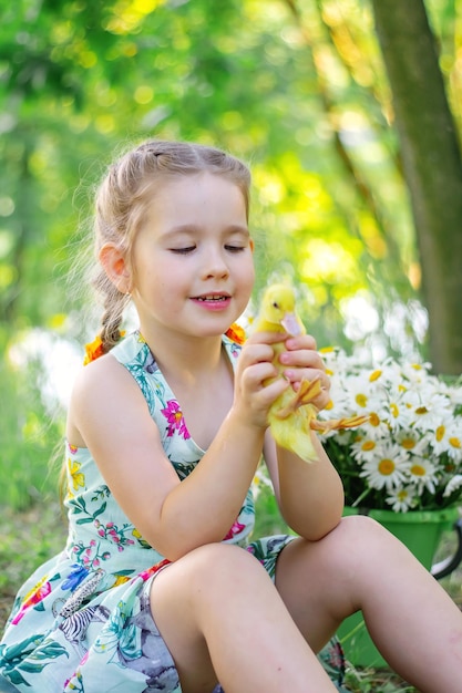 A girl and a duckling in the summer outdoors Gute babies Happiness