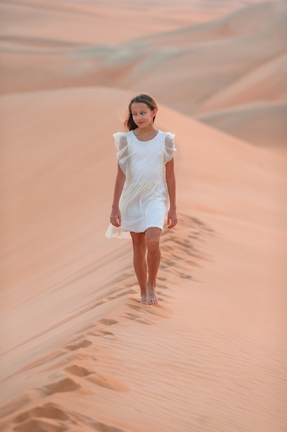 Girl among dunes in desert in United Arab Emirates