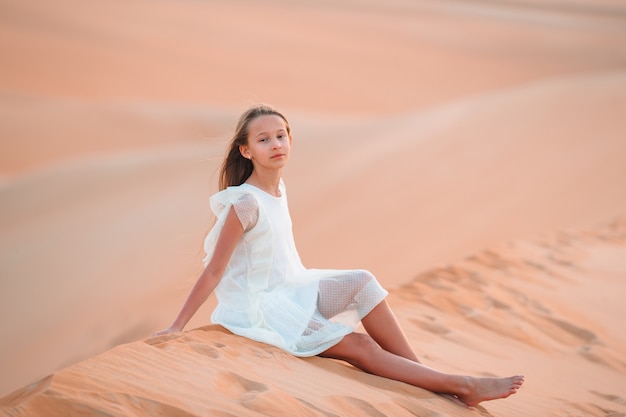 Girl among dunes in desert in United Arab Emirates