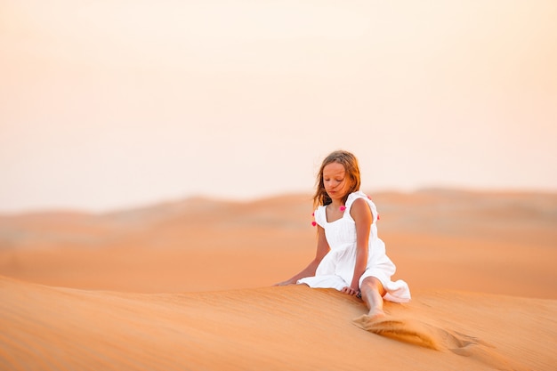 Girl among dunes in desert in United Arab Emirates