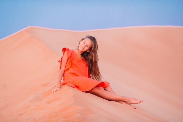 Girl among dunes in Rub al-Khali desert in United Arab Emirates