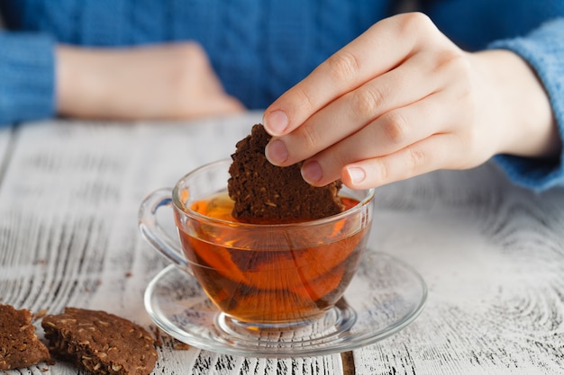 Girl dunk biscuits in tea