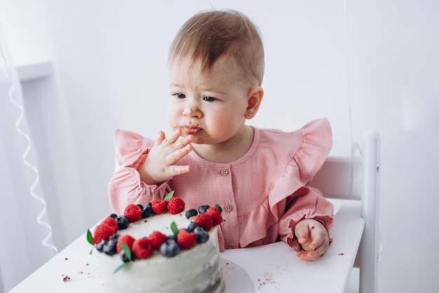 Girl eating a birthday cake with berries birthday