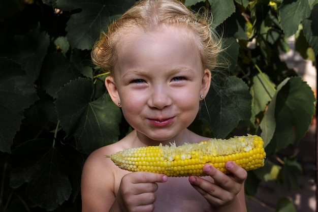 Girl eating corn on the street under natural light. Real people.