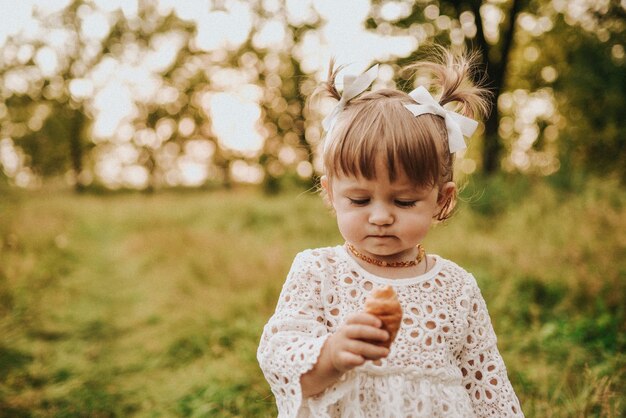 Girl eating croissant in the forest