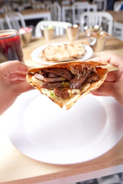 おいしい典型的なメキシコ料理のタコスを食べる女の子 sopes 牧師など