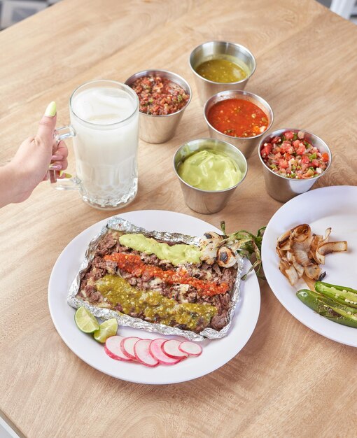 おいしい典型的なメキシコ料理のタコスを食べる女の子 sopes 牧師など