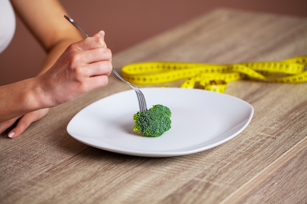Girl eating diet broccoli for weight loss