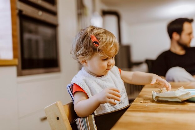 Photo girl eating food at table in home