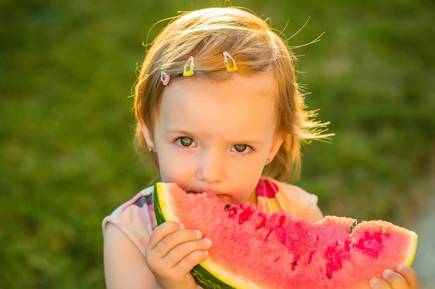 Девушка ест красный арбуз на открытом воздухе