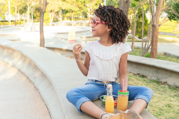 Girl eating vegetables during the day