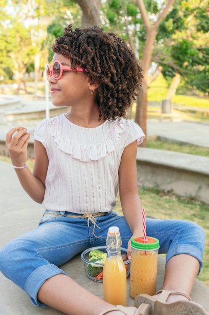 Girl eating vegetables during the day