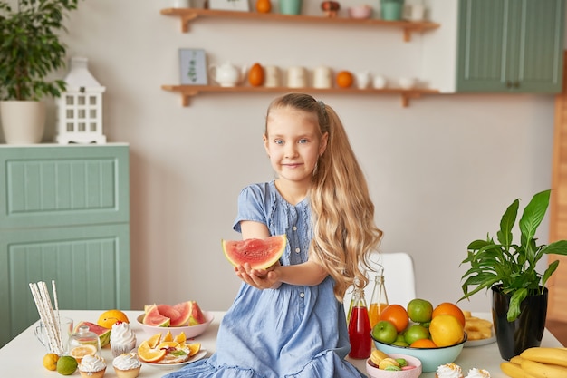 Girl eats fruit at the kitchen