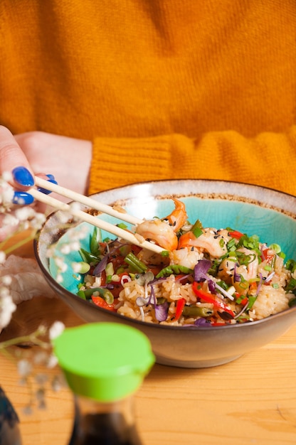 A girl eats garlic rice with shrimp in a restaurant