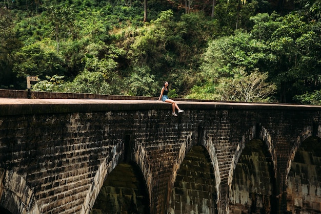 橋の端にいる女の子。 9アーチ橋。アジアへの旅。スリランカへの旅行。橋の上の男。アジアの観光。スリランカへの遠足。植民地時代の遺産