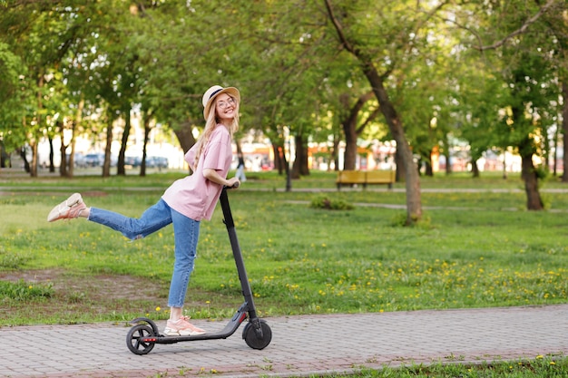 Girl on an electronic scooter in a city park in the summer