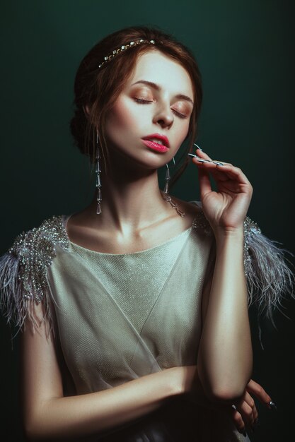 Girl in an elegant dress posing in a studio