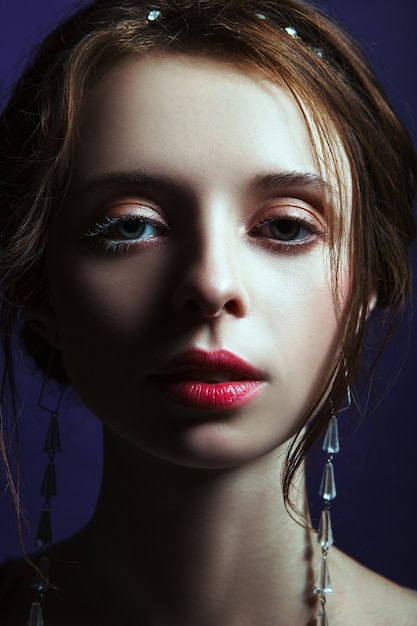 Girl in an elegant dress posing in a studio