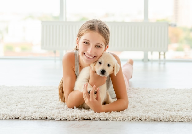 Girl embracing retriever puppy