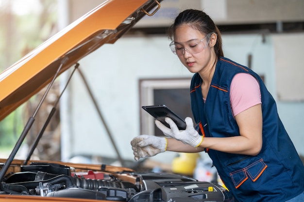 Girl engineer mechanics working on a vehicle in a garage or service wo