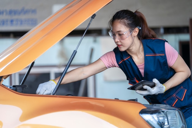 Girl engineer mechanics working on a vehicle in a garage or service wo