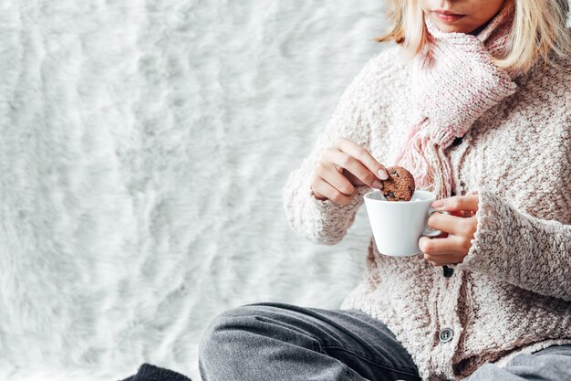 A girl enjoying a cookies and a cup of hot chocolate on winter season