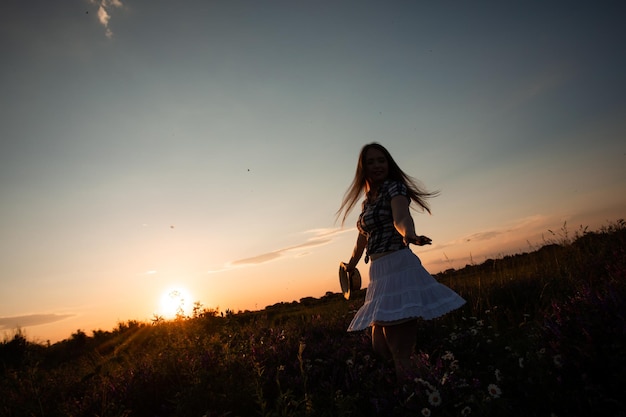 Girl enjoying freedom watching sunset in meadow