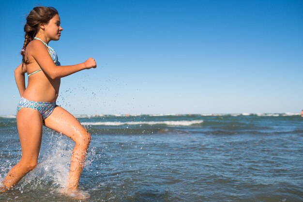 The girl enjoying the warm breeze runs along the sea