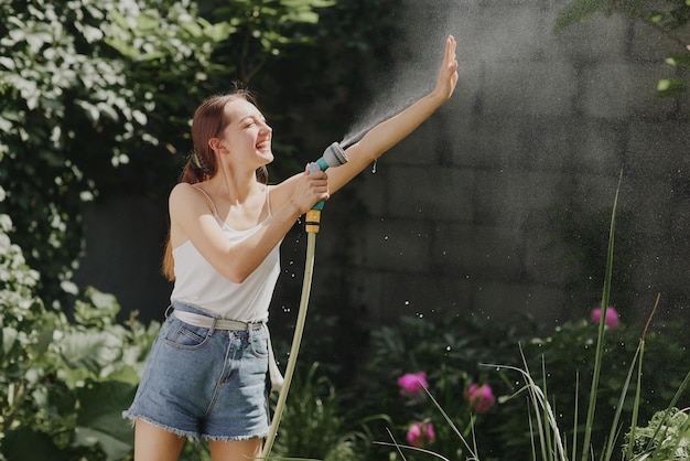 Girl enjoying water in the heat of summer in the garden