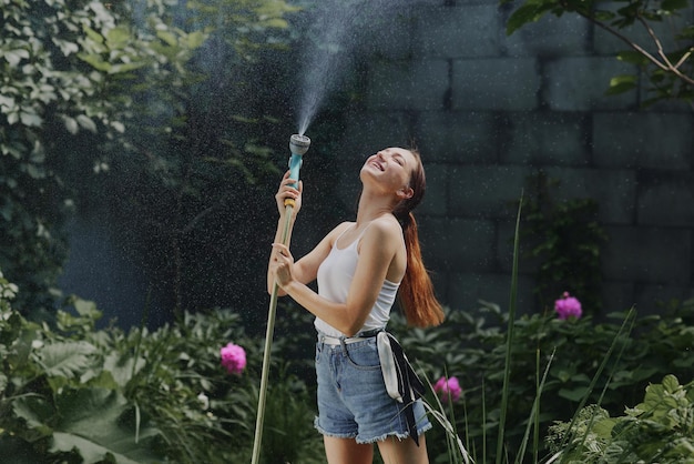 Girl enjoying water in the heat of summer in the garden