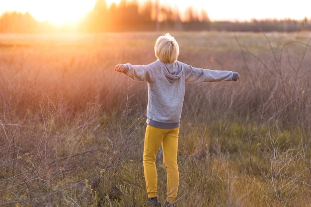 Foto una ragazza si gode il tramonto nei campi in autunno.